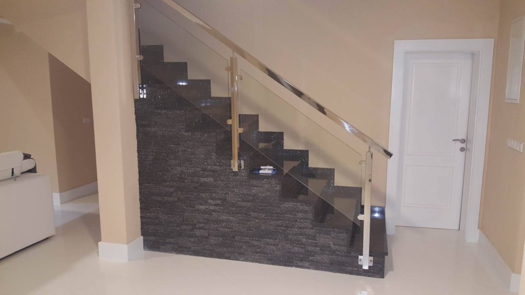 Glass railing on a black marble staircase