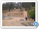 Screenshot of a construction site with a first-floor house frame being erected